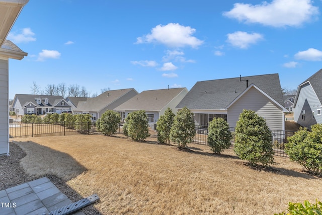 rear view of house with a yard, fence, and a residential view