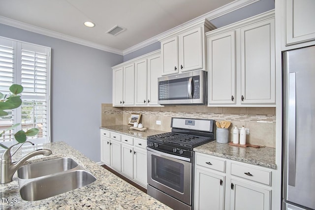 590 Grand Central Sta, Apex, NC 27502 - kitchen featuring stainless steel appliances, ornamental molding, white cabinets, tasteful backsplash, and light stone countertops