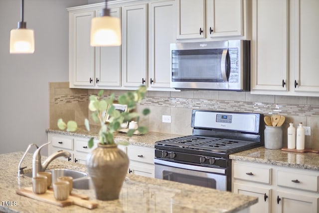 590 Grand Central Sta, Apex, NC 27502 - kitchen featuring stainless steel appliances, white cabinets, backsplash, light stone counters, and pendant lighting
