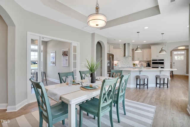 142 Oban Dr, Home, Sanford, NC 27330 - dining area with baseboards, visible vents, arched walkways, and light wood-style floors