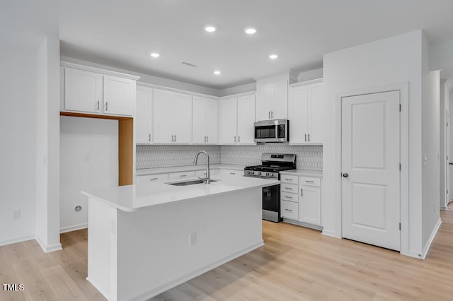 52 Shay St, Angier, NC 27501 - kitchen featuring appliances with stainless steel finishes, decorative backsplash, white cabinetry, light countertops, and light wood-type flooring