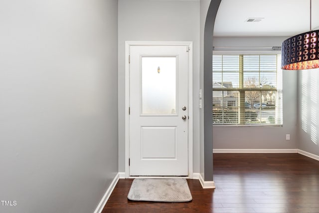 entryway featuring hardwood / wood-style flooring, baseboards, visible vents, and arched walkways