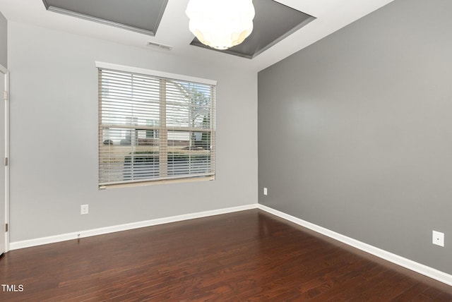 unfurnished room with visible vents, baseboards, and wood finished floors