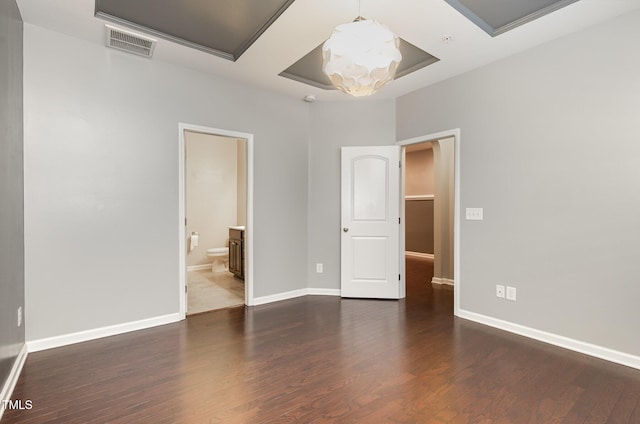 interior space featuring a notable chandelier, baseboards, visible vents, and wood finished floors