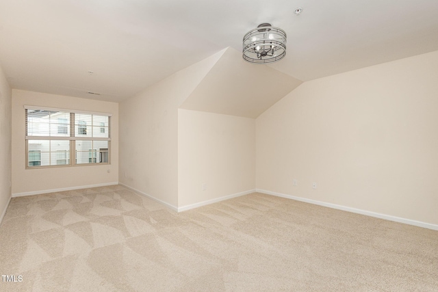 additional living space with baseboards, lofted ceiling, and light colored carpet