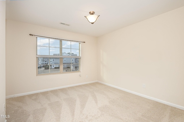 carpeted spare room with visible vents and baseboards