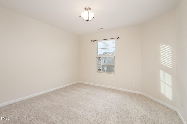 empty room with light carpet, visible vents, and baseboards