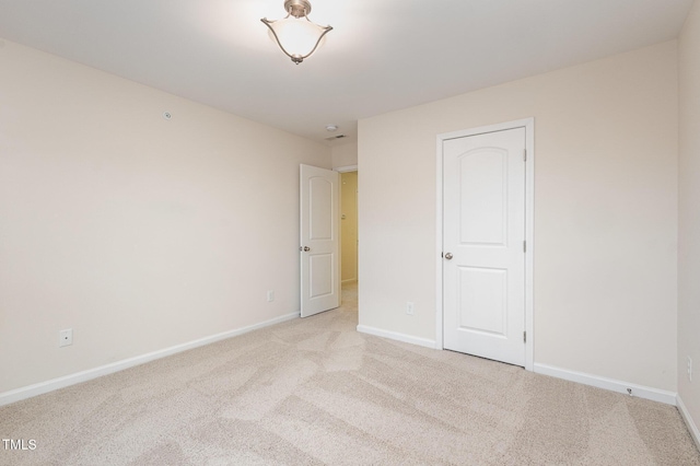 unfurnished bedroom featuring light carpet and baseboards