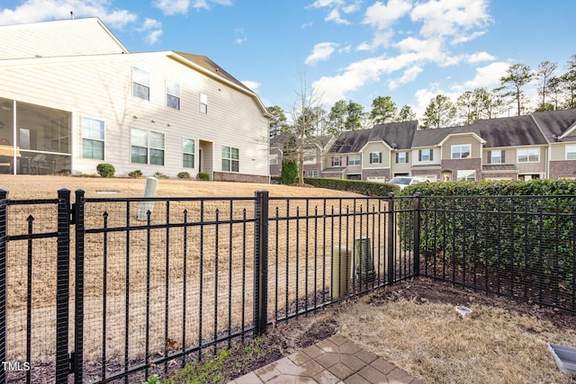 view of patio with a sunroom, a fenced backyard, and a residential view