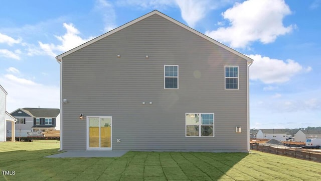 rear view of house with a patio area, fence, and a lawn