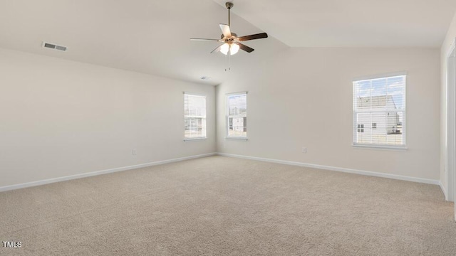 empty room featuring ceiling fan, light colored carpet, visible vents, baseboards, and vaulted ceiling