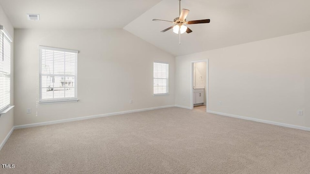 empty room with ceiling fan, visible vents, vaulted ceiling, and light colored carpet