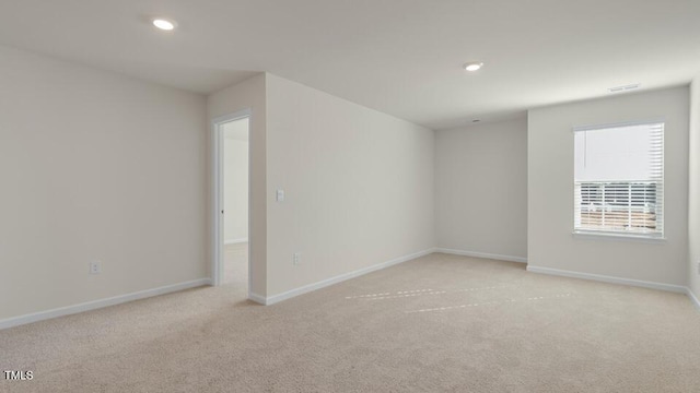 spare room featuring baseboards, light colored carpet, and recessed lighting