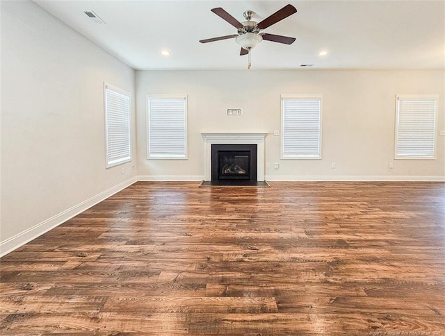 unfurnished living room with baseboards, a ceiling fan, a fireplace with flush hearth, wood finished floors, and recessed lighting