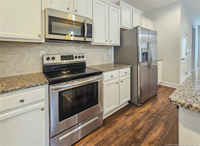 kitchen with stainless steel appliances, stone countertops, and dark wood finished floors