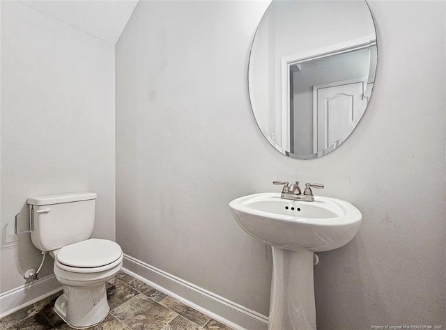 bathroom with toilet and baseboards