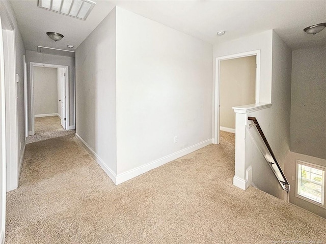 corridor featuring an upstairs landing, baseboards, visible vents, and light colored carpet