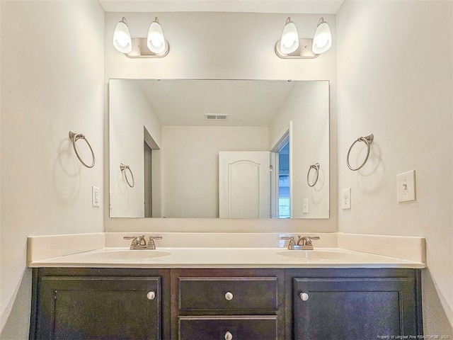 bathroom with double vanity, visible vents, and a sink