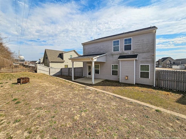 back of house with a patio, a yard, and a fenced backyard