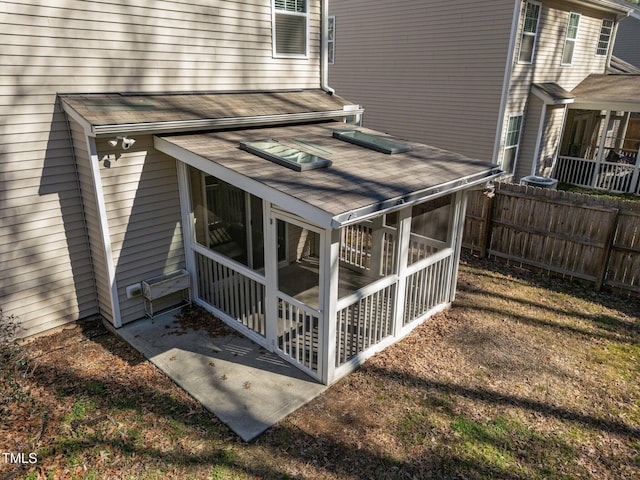 exterior space featuring a sunroom and fence