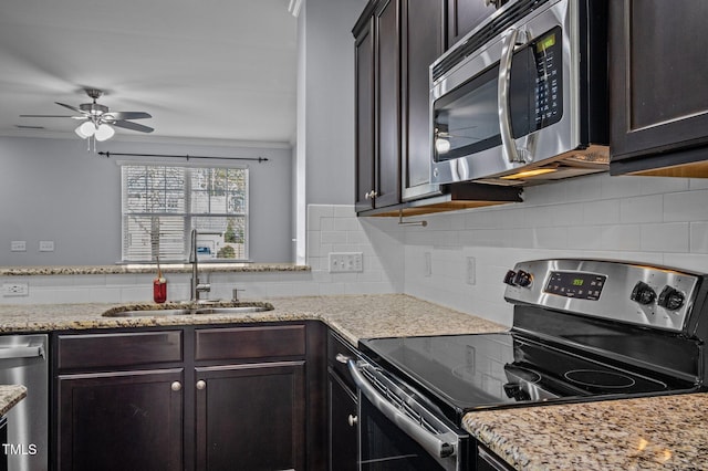 kitchen featuring dark brown cabinetry, appliances with stainless steel finishes, a sink, and ornamental molding