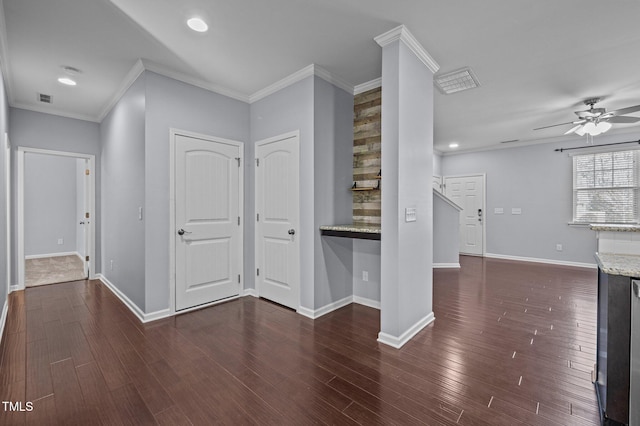 interior space featuring baseboards, visible vents, dark wood finished floors, and crown molding