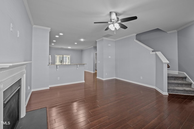 unfurnished living room featuring stairs, a fireplace, wood finished floors, and crown molding