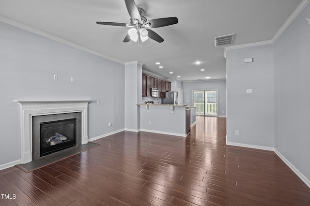 unfurnished living room featuring baseboards, visible vents, a fireplace with flush hearth, ornamental molding, and dark wood-style flooring