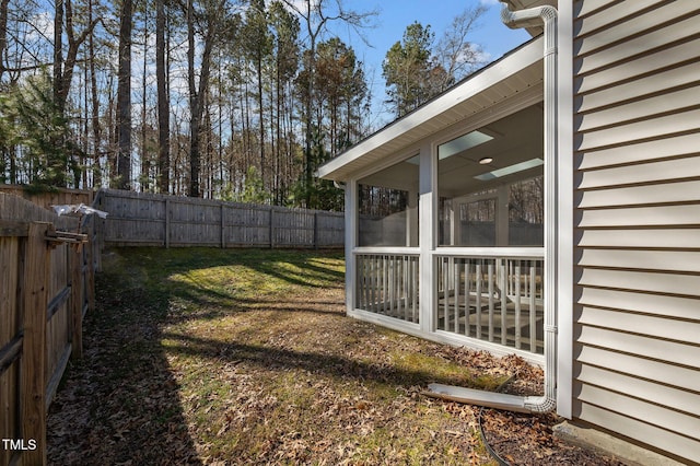 view of yard featuring a sunroom and a fenced backyard