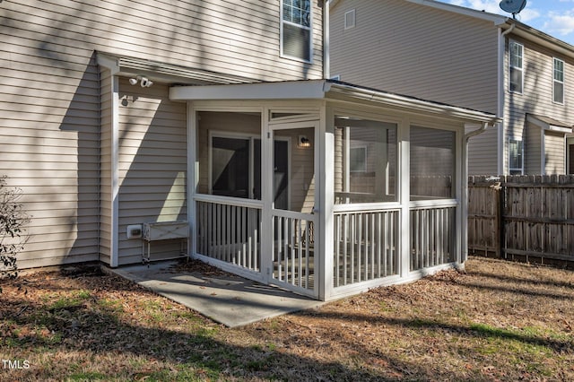 view of property exterior with fence and a sunroom