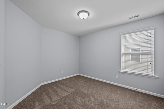 carpeted empty room featuring visible vents and baseboards