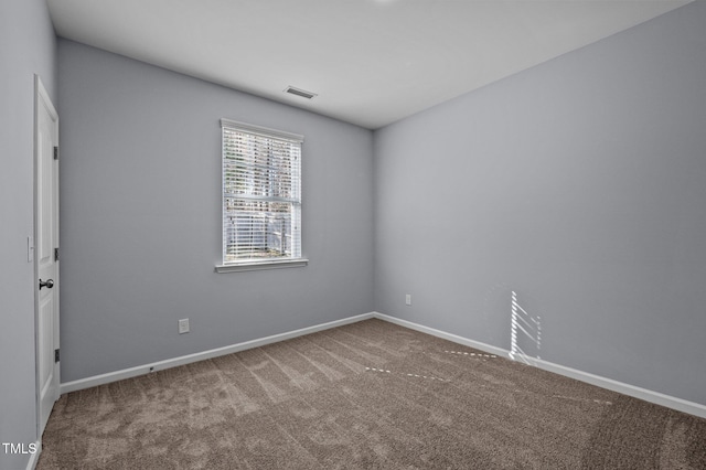 empty room featuring carpet floors, baseboards, and visible vents