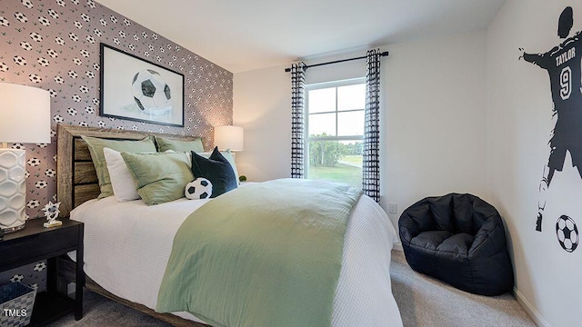 bedroom with baseboards, an accent wall, carpet floors, and wallpapered walls