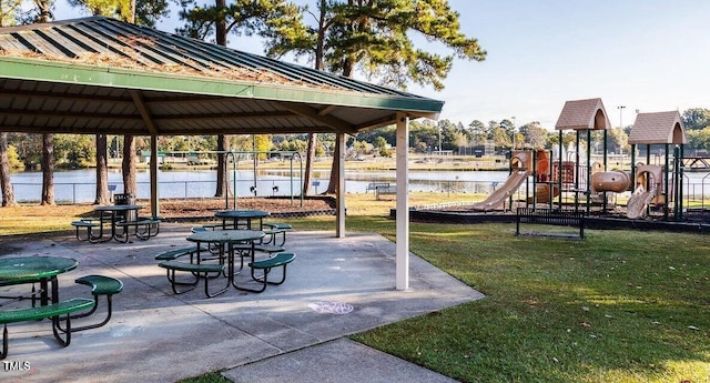 view of community featuring a water view, playground community, a gazebo, and fence