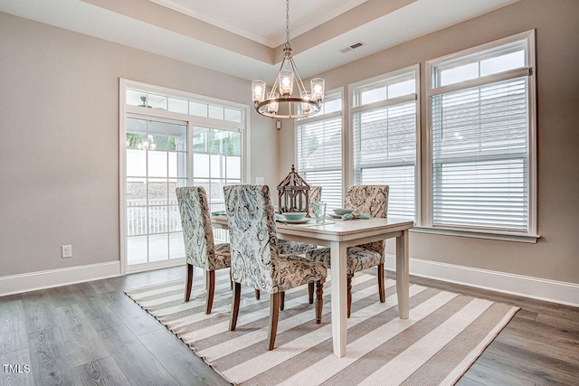 129 Oban Dr, Home, Sanford, NC 27330 - dining area featuring a notable chandelier, visible vents, baseboards, dark wood-style floors, and a raised ceiling