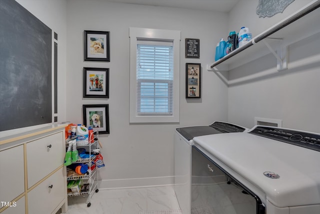 clothes washing area with marble finish floor, laundry area, washing machine and clothes dryer, and baseboards