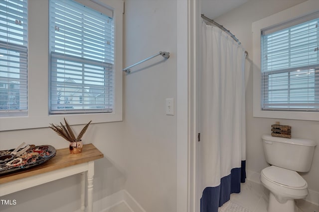 full bathroom with baseboards, a shower with shower curtain, and toilet