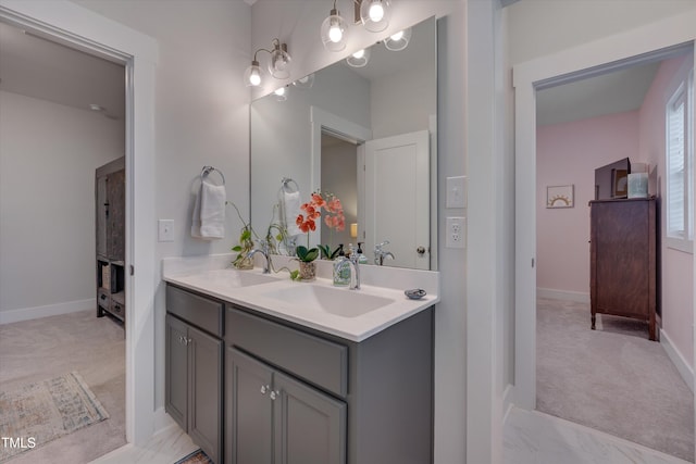 bathroom featuring double vanity, a sink, and baseboards