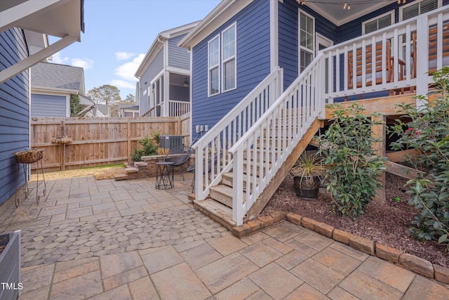 view of patio / terrace with stairway, fence, and central air condition unit