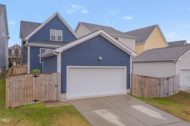 traditional home featuring a garage, driveway, a front lawn, and fence