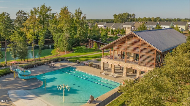 community pool featuring a patio area, fence, and a residential view