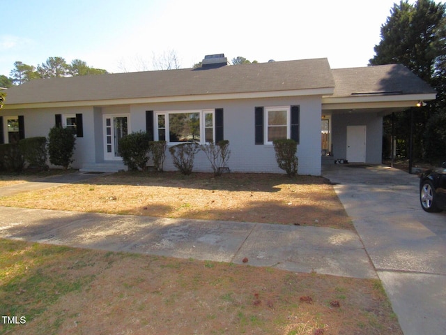 single story home featuring a carport, concrete driveway, and brick siding