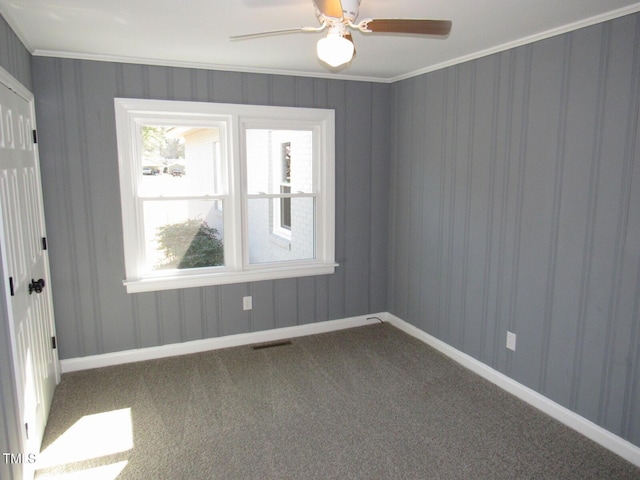 unfurnished room featuring baseboards, carpet flooring, visible vents, and crown molding