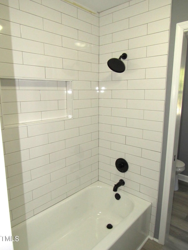 bathroom featuring bathtub / shower combination and toilet