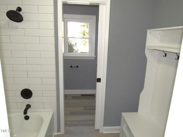 full bath featuring shower / bathtub combination, wood finished floors, and baseboards