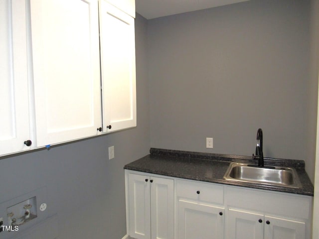 clothes washing area featuring washer hookup, a sink, and cabinet space