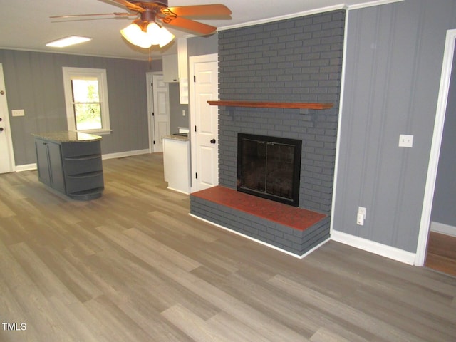 136 Dogwood Trl, Wendell, NC 27591 - unfurnished living room featuring ceiling fan, baseboards, a fireplace, wood finished floors, and ornamental molding