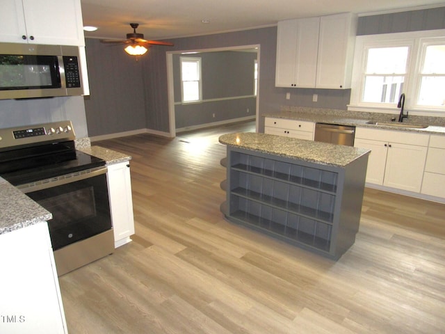 136 Dogwood Trl, Wendell, NC 27591 - kitchen with stainless steel appliances, a sink, light wood-type flooring, white cabinets, and a ceiling fan
