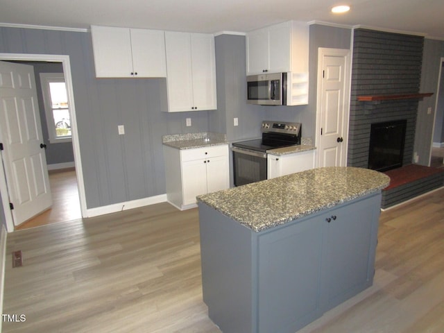 136 Dogwood Trl, Wendell, NC 27591 - kitchen featuring appliances with stainless steel finishes, baseboards, light wood-style floors, white cabinetry, and ornamental molding