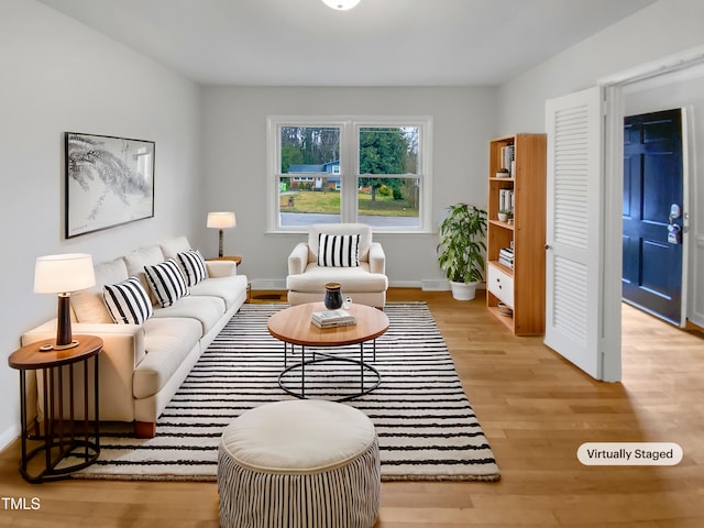 living area with light wood-style flooring and baseboards